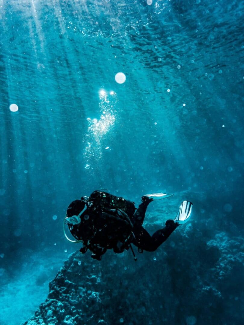 A scuba diver in the ocean under water.