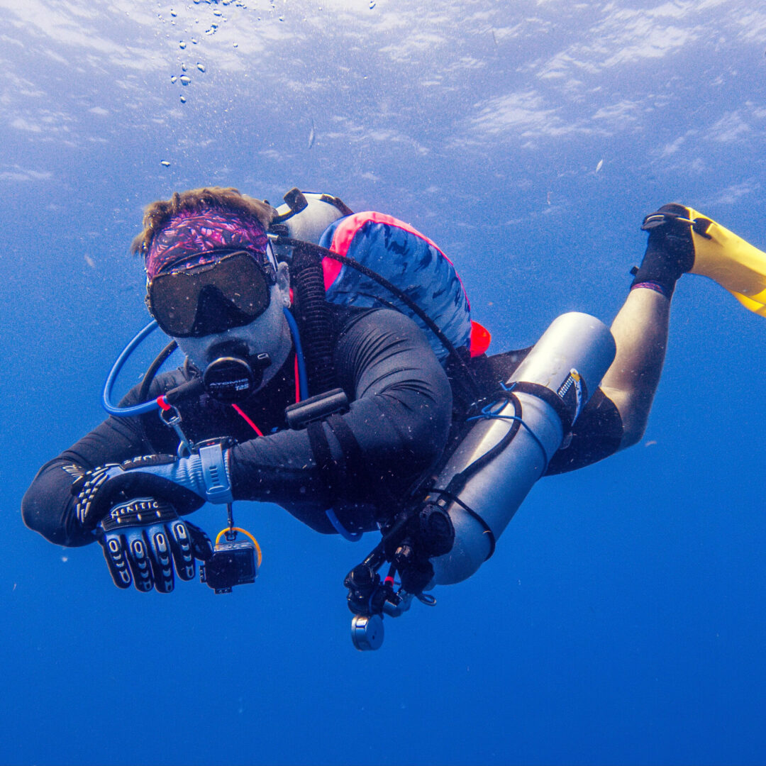 A scuba diver is taking pictures underwater.