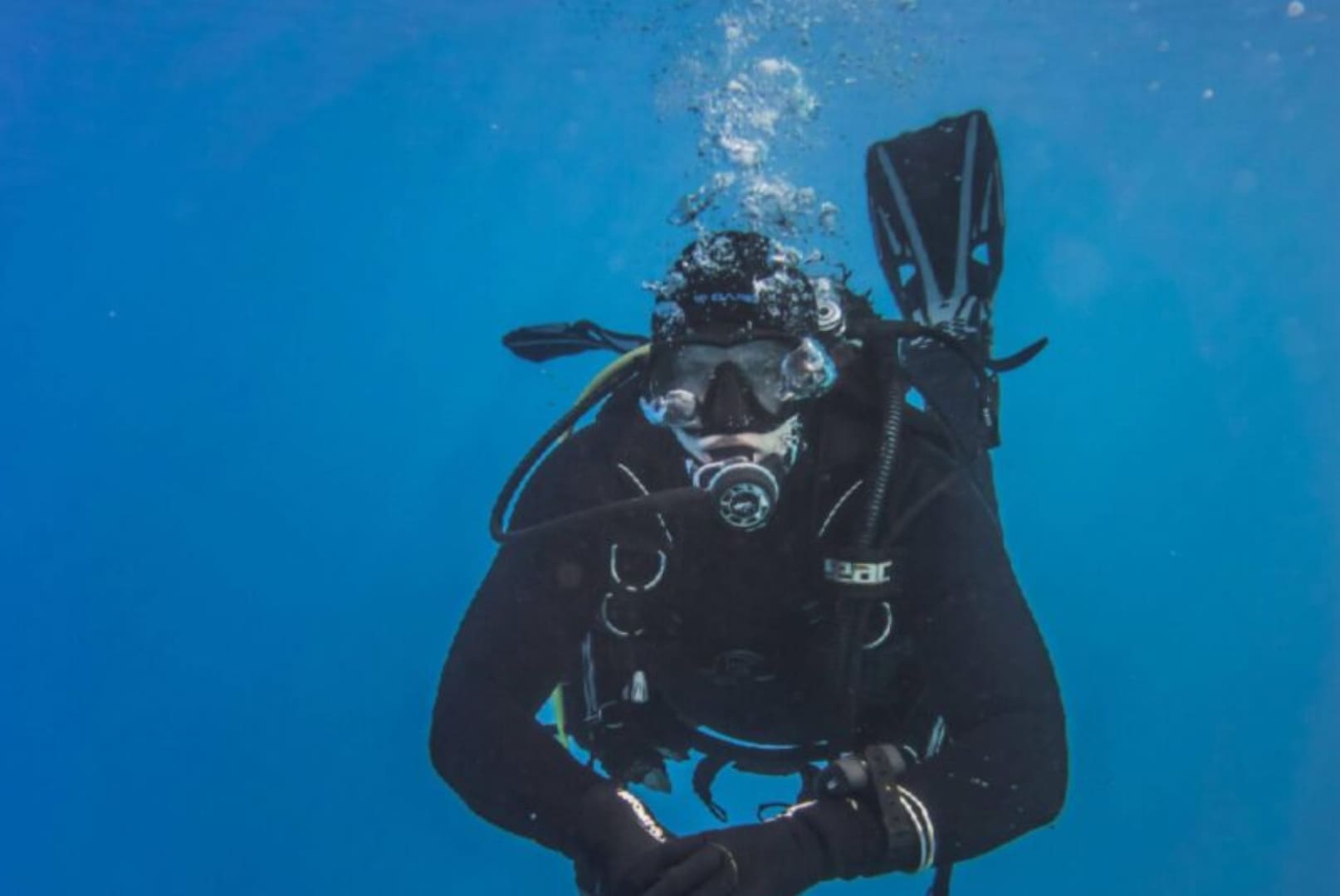 A scuba diver is in the water with his gear.