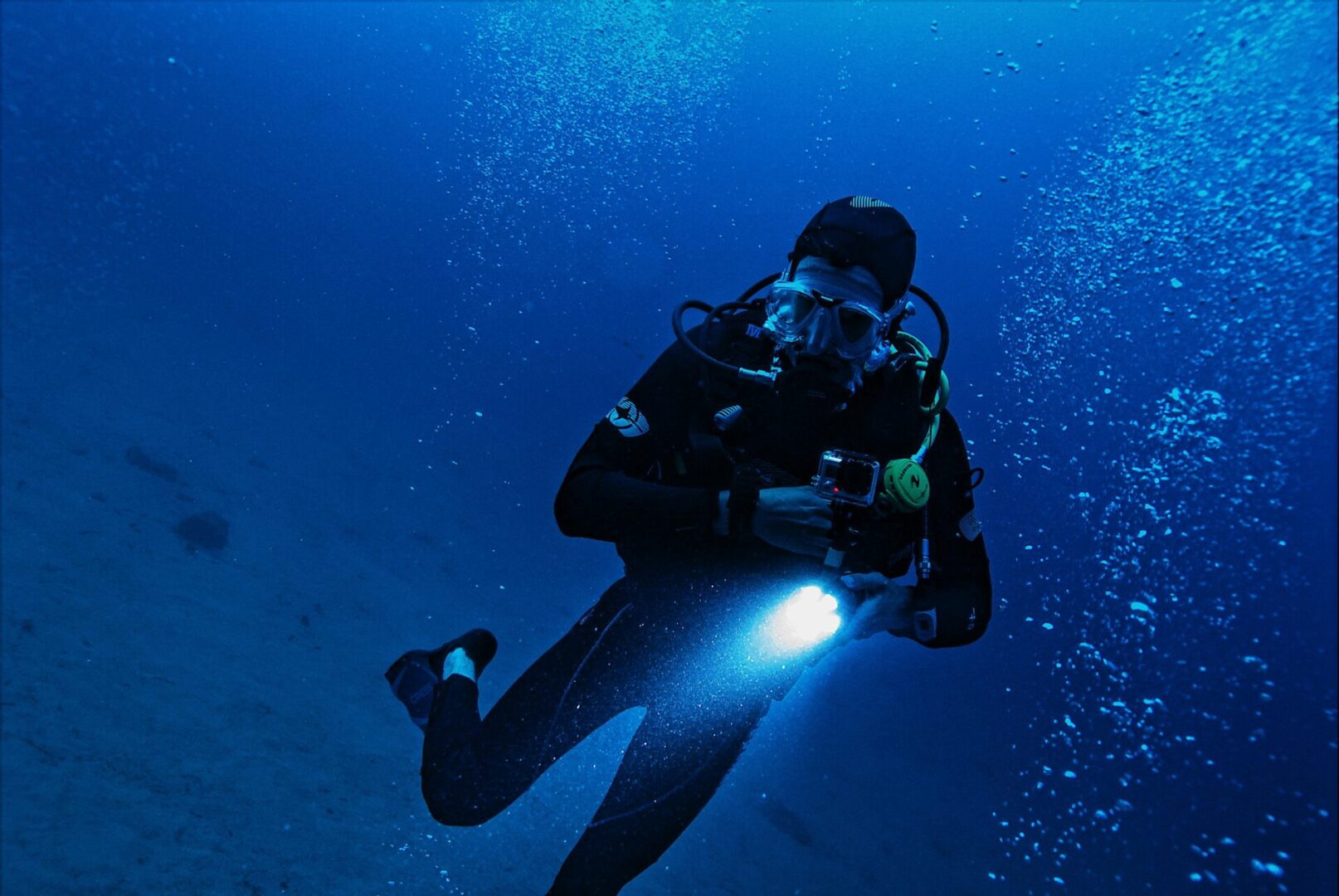 A scuba diver is underwater with a light.