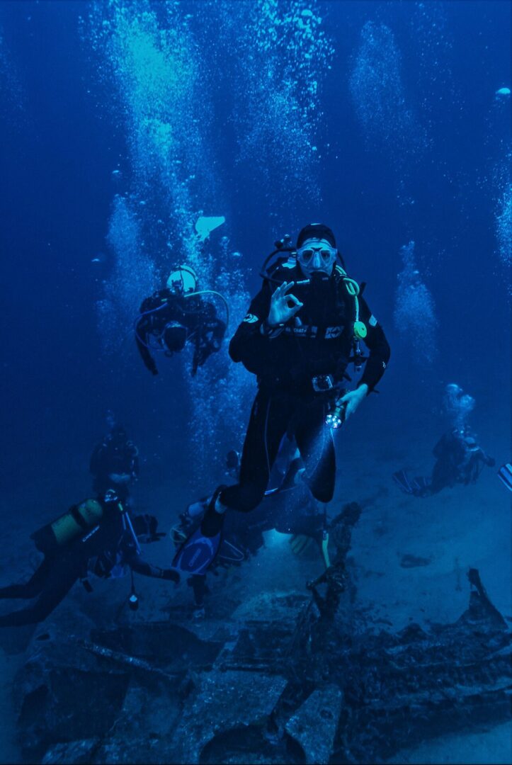 A group of scuba divers swimming in the ocean.